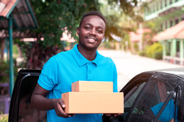 African man carrying package from delivery car