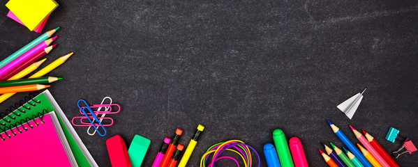 Wall Mural - School supplies corner border banner. Overhead view on a chalkboard background with copy space. Back to school concept.