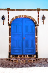 Beautiful old blue door on white facade of greek architecture, Santorini island, Greece, Europe. Beautiful details of the island of Santorini. Famous travel destination