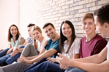 Wall Mural - People sitting together near brick wall. Unity concept