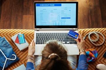 woman with credit card looking at checkout screen on website