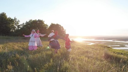 Wall Mural - People in traditional Russian clothes are dancing on the circle with the balalaika playing