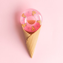 Flat Lay Of Inflatable Swimming Pool Float In Ice Cream Cone Abstract Isolated On Rose.