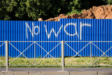 Blue Fence Of Metal Sheets, Enclosing The Construction Site And The Inscription No War. Pacifism And Graffiti.
