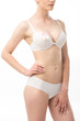 © LIGHTFIELD STUDIOS - cropped view of young woman in underwear with pink ribbon isolated on white