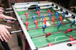 Detail of kid's hands playing the foosball table match. Soccer game, friends recreation