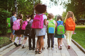 small schoolchildren with colorful school bags and backpacks run to school. back to school, educatio