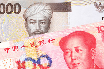 A gray two thousand Indonesian rupiah bank note with a red, one hundred Chinese yuan 