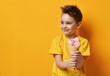 © Dmitry Lobanov - Baby boy kid eating strawberry ice-cream in waffles cone happy screaming laughing on yellow background