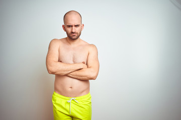 Poster - Young shirtless man on vacation wearing yellow swimwear over isolated background skeptic and nervous, disapproving expression on face with crossed arms. Negative person.