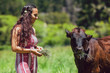 Mixed race young woman feeds cows on a farm