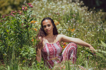mixed race young woman reclines in grass on a farm