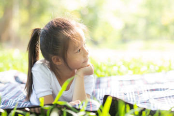 Portrait face of cute asian little girl and child happiness and fun in the park in the summer, smile and happy from asia kid and relax in the garden, lifestyle childhood concept.