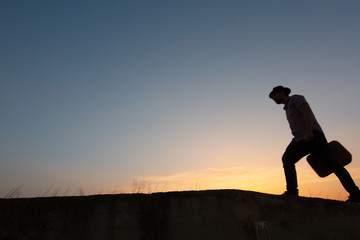 Sticker - silhouette of man with suitcase at sunrise