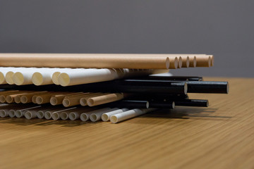 Bundle of paper straws white, brown and black in a wood table display background, great for environmental purpose