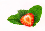 Przekrojona truskawka na zielonych lisciach. Truskawki i mieta. Truskawk an bialym tle.