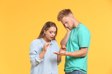 Sticker - Troubled couple counting coins against color background