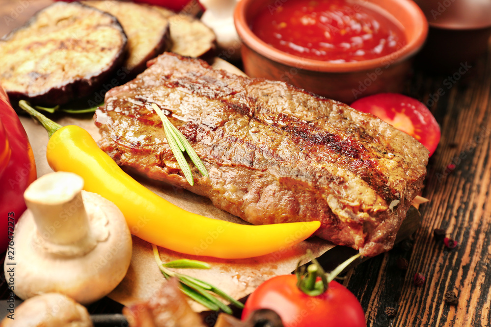 Tasty grilled meat with vegetables on table, closeup