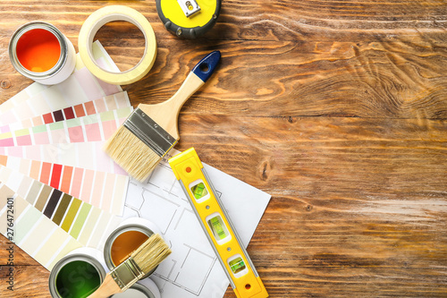 Fotografía Cans of paint with supplies, palette samples and house plan on wooden table