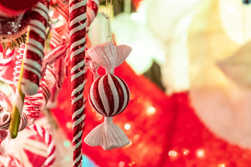 Decorative Christmas toy in a form of a large candy with red stripes on a Christmas tree