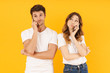 © Drobot Dean - Portrait of happy couple man and woman in basic t-shirts standing together while talking on smartphones