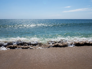 Waves on a sunny beach without objects and people. Copy space.