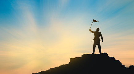 silhouette of man on mountain top over sky and sun light background,business, success, leadership, achievement and people concept