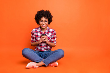 Poster - Full body photo funny lady sit floor hold hands paper coffee mug rest adorable amazing wear specs casual checkered plaid shirt isolated orange background