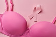 © LIGHTFIELD STUDIOS - ribbon near bra on light pink background, breast cancer concept