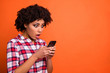 © deagreez - Close up side photo of stupor model lady hold hands telephone reader email boss fired wear casual checkered plaid shirt isolated orange bright background