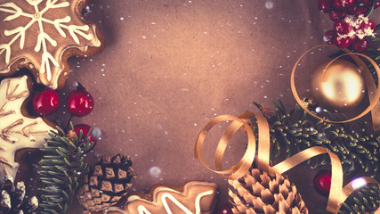 Wall Mural - christmas dark background frame in bright golden brown tones. fir branches, cones, gingerbread cooki