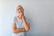 © Dragana Gordic - Close up portrait of a professional business woman smiling. Portrait of cheerful mature woman standing against grey wall. Close up portrait of beautiful older woman smiling and standing by wall