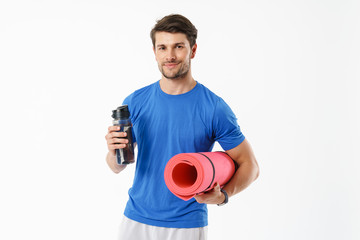 Poster - Photo of caucasian man wearing casual t-shirt smiling while carrying fitness mat and water bottle