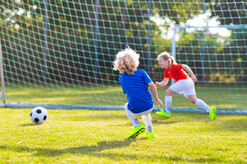 Wall Mural - Kids play football. Child at soccer field.