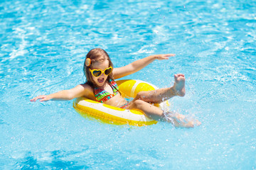 Wall Mural - Child in swimming pool on ring toy. Kids swim.