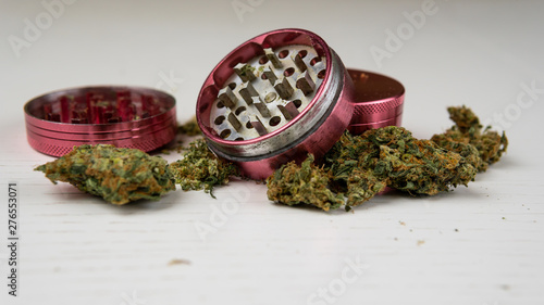 Medical marijuana buds and grinder on the white table Poster Mural XXL