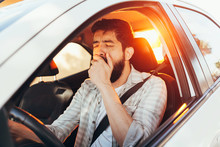Tired Man Yawning While Driving His Car