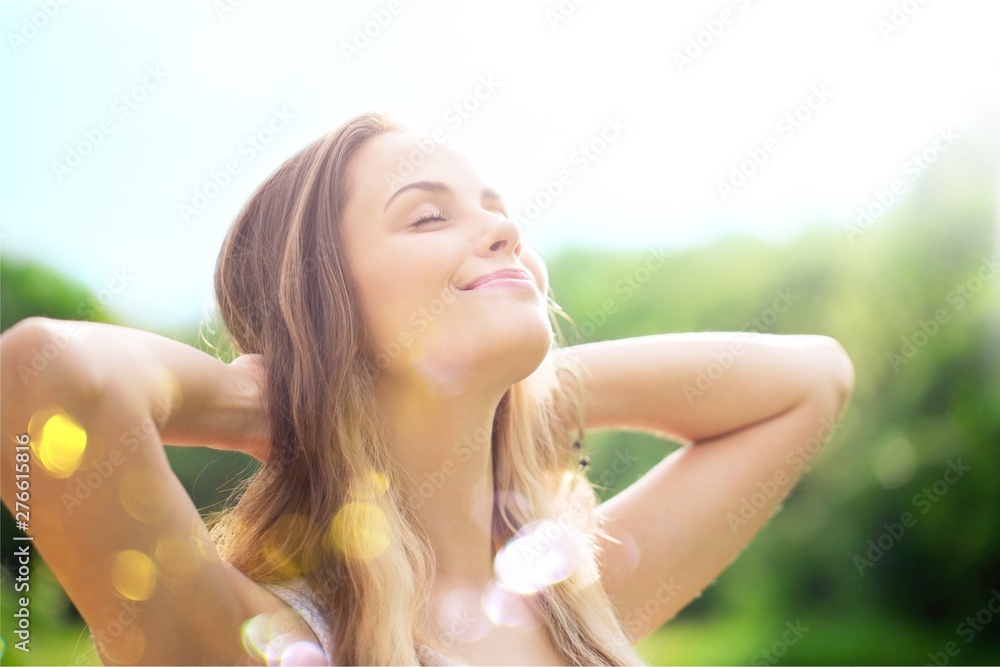 Young relaxed woman on blurred nature background - obrazy, fototapety, plakaty 