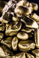 Wall Mural - Gold nugget, large gold stone closeup isolated on black background. Concept of finance, luxury or wealth.