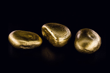 Wall Mural - Gold nugget, large gold stone closeup isolated on black background. Concept of finance, luxury or wealth.