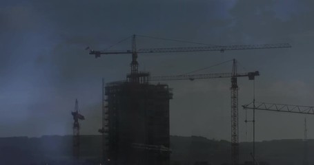 Wall Mural - cranes on top of a building and lightning