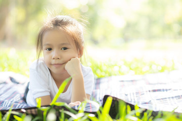 Portrait face of cute asian little girl and child happiness and fun in the park in the summer, smile and happy from asia kid and relax in the garden, lifestyle childhood concept.