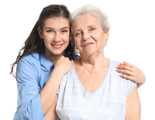 Young caregiver with senior woman on white background