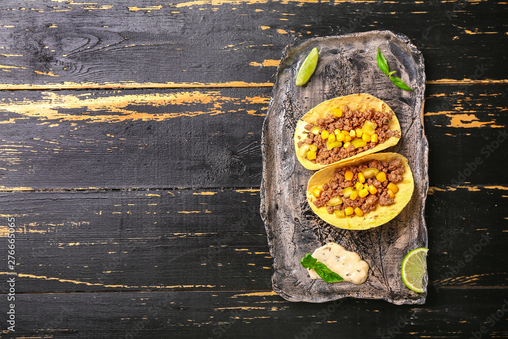 Plate with tasty fresh tacos on wooden background