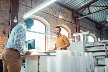 Canvas Print - Handsome bearded colleague smiling while talking to his friend