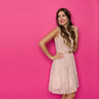 © studioloco - Smiling Beautiful Woman In Beige Lace Mini Dress Is Looking Away Over The Shoulder At Pink Copy Space