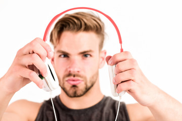 modern music. new technology in modern life. sexy muscular man listen music. man listen new song isolated on white. unshaven man in blue tooth technology earphones. moder life concept