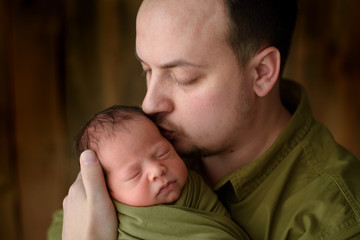 Wall Mural - Father holds with love his newborn son.