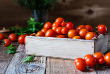 Crate Of Freshly Picked Organic Cherry  Tomatoes On Rustic  Table