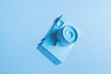 Close-up Of Painted Camera In Air Against Blue Backdrop